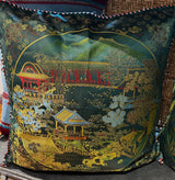 Decorative pillow with a landscape design featuring buildings and trees on a green background.
